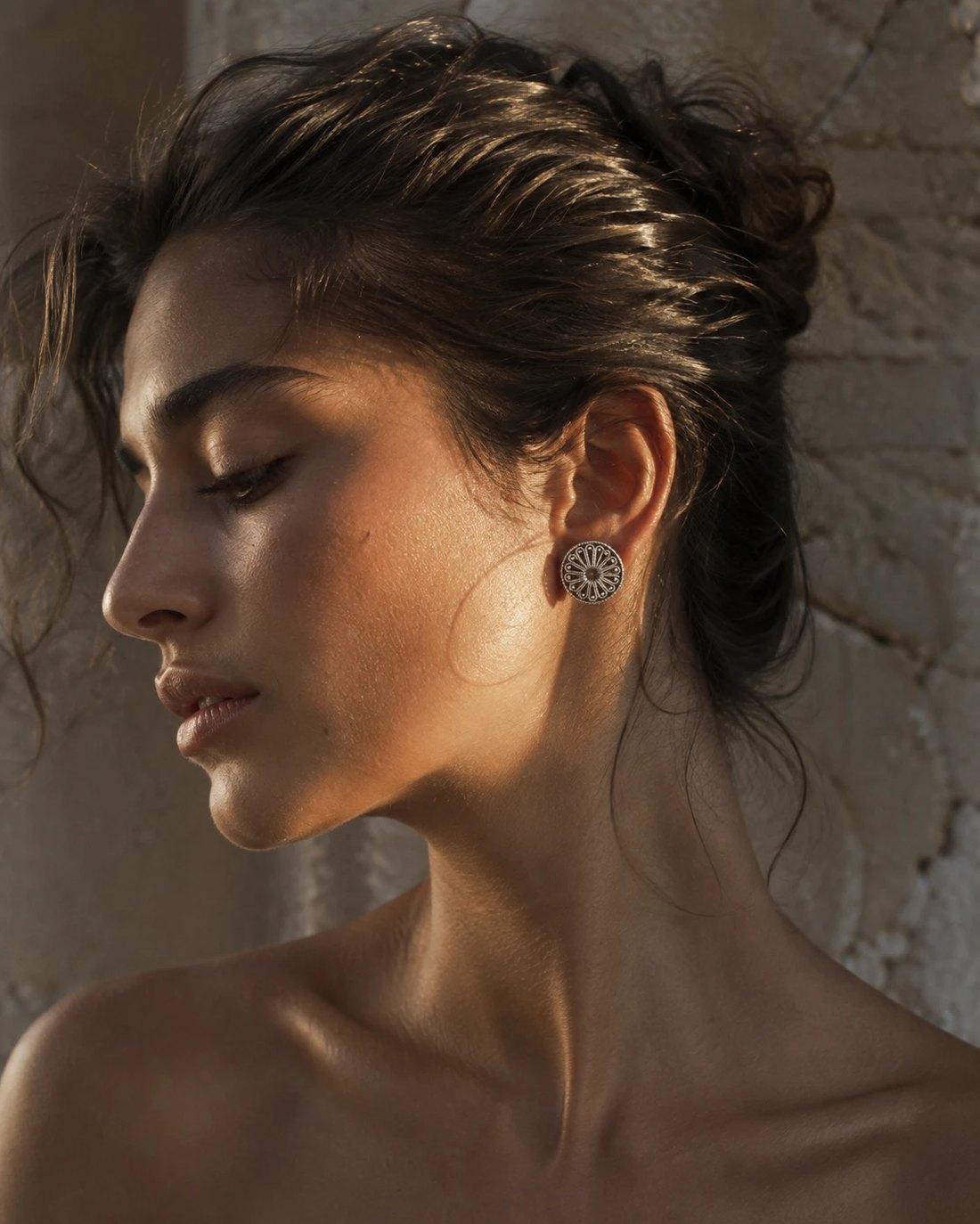 Profile portrait in raking sunlight with a silver earring